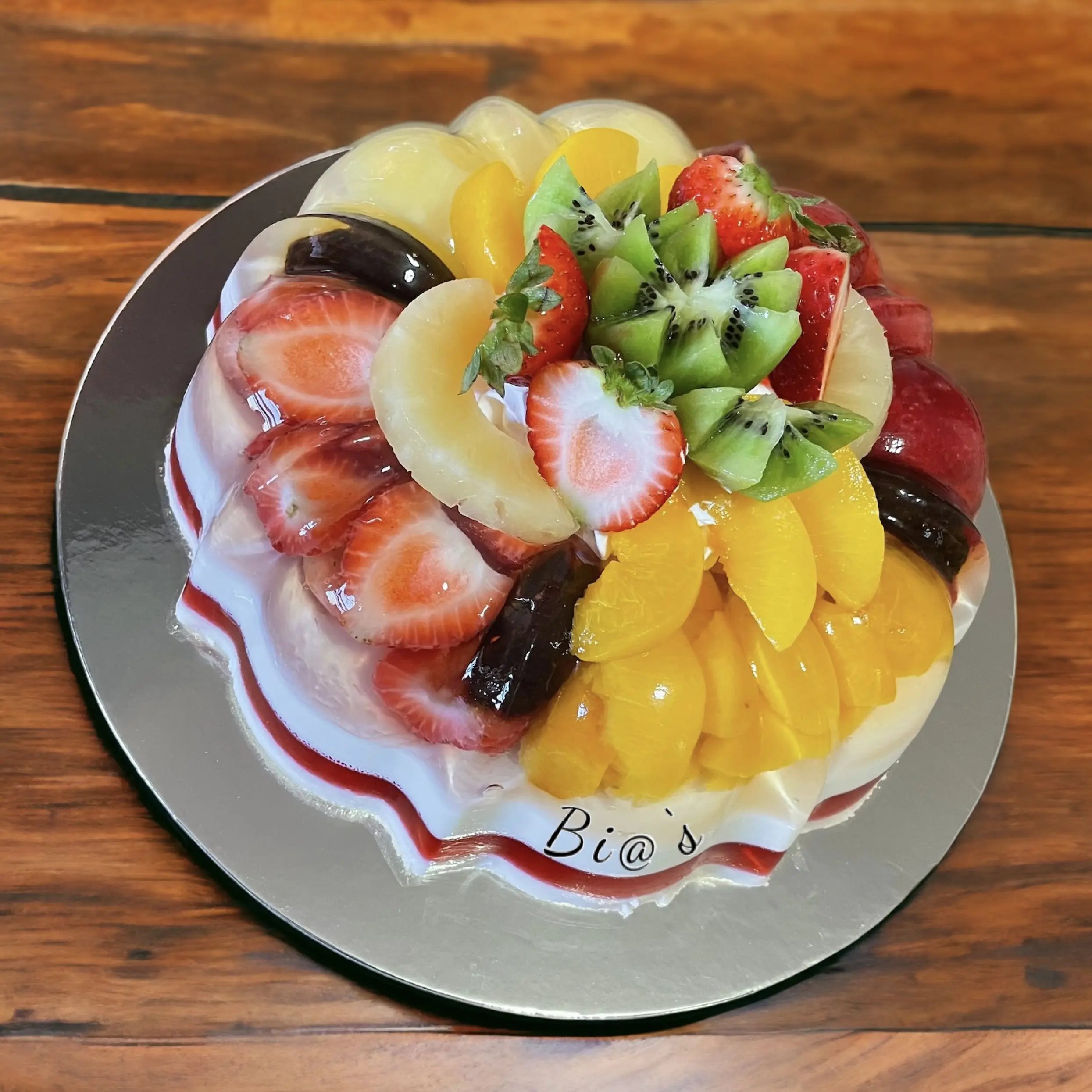 Gelatin cake topped with fresh kiwi, strawberries, and peaches, made in Lincoln, Nebraska