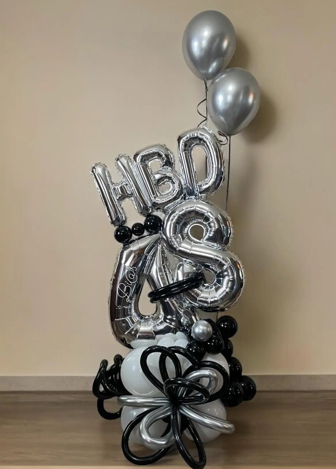 Silver HBD letter balloons with a black and white base, styled in Lincoln, Nebraska