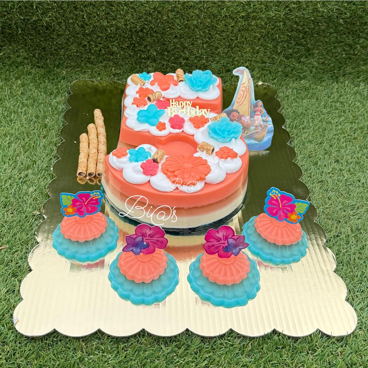 Two tier coral and teal cake with matching cupcakes, handmade in Lincoln